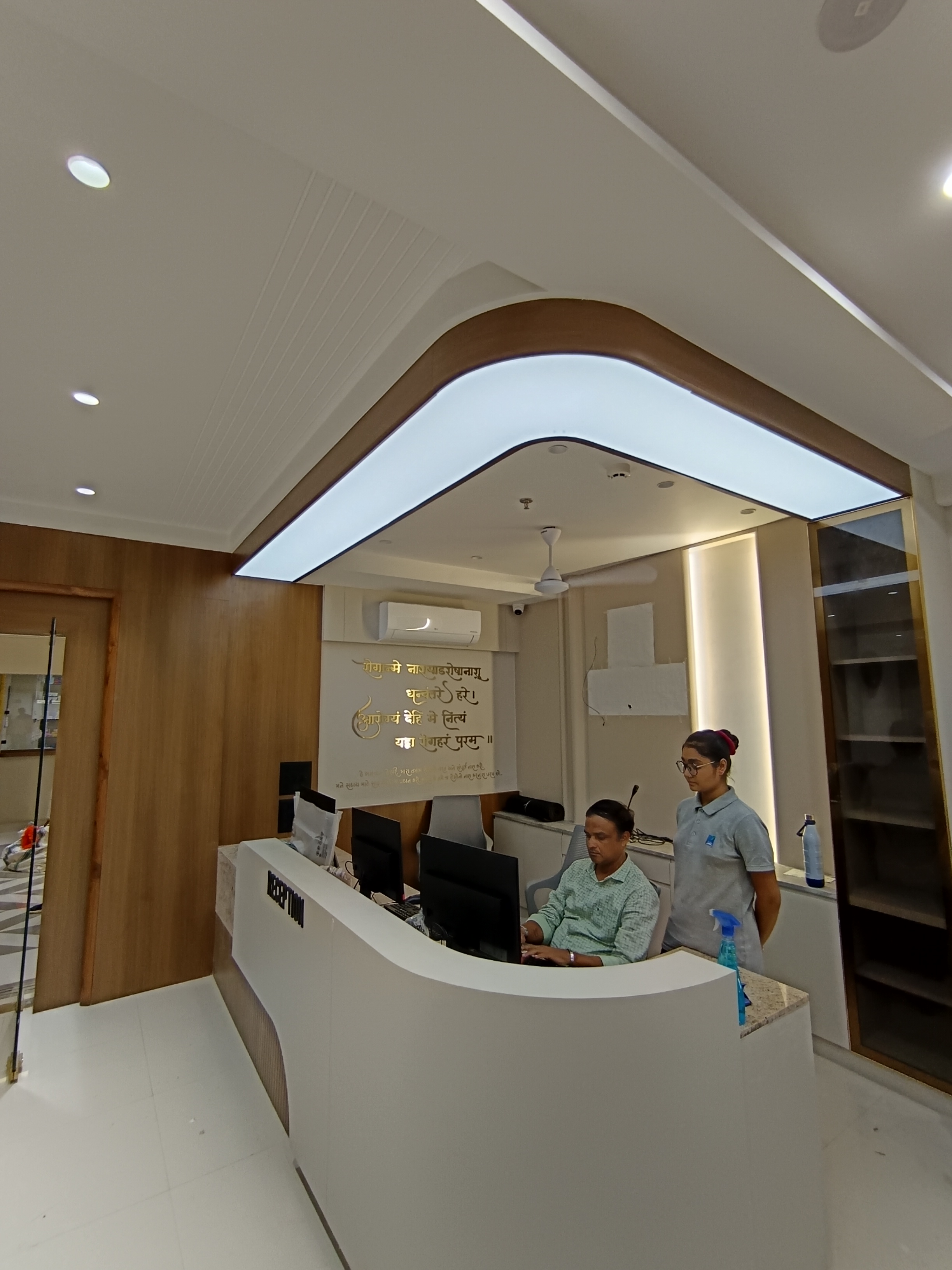 Actual BION plain-white backlit stretch ceiling following a curved reception layout